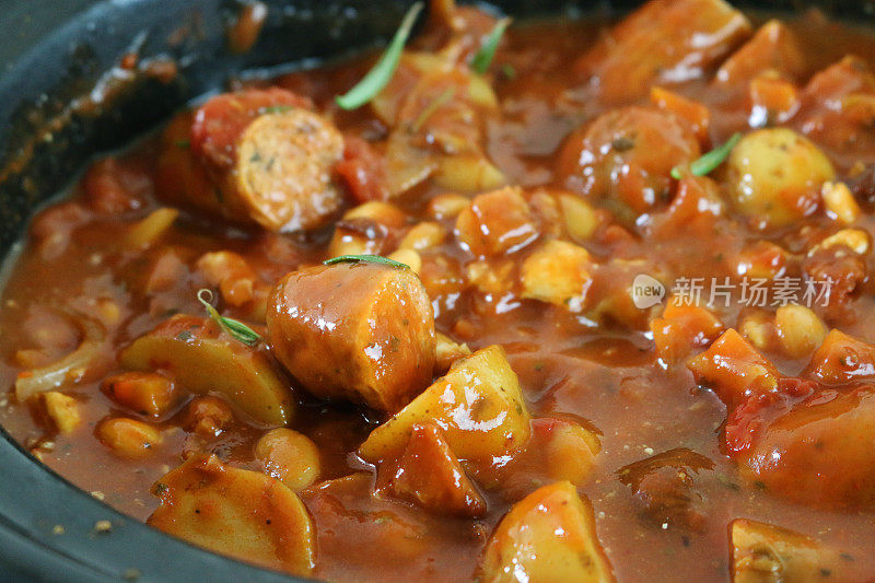 自制的香肠砂锅配土豆、胡萝卜和豆子，配上新鲜的香草，美味的番茄肉汁/炖菜
